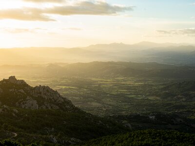 Sunrise view of grassland landscape and mountain range panorama from Monte Pino, Sardinia, Italy